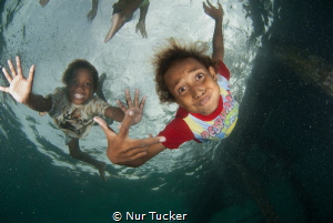 Local children of the Arborek Jetty by Nur Tucker 